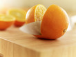 Knife slicing orange on cutting board