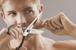 Portrait of man holding scissors and pulling skin on face