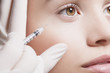 Close up of woman receiving botox injection under eye