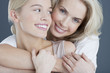 Close up portrait of smiling mother and daughter hugging