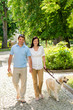 Photo: Young couple in love walking dog park Young couple in love walking dog park
