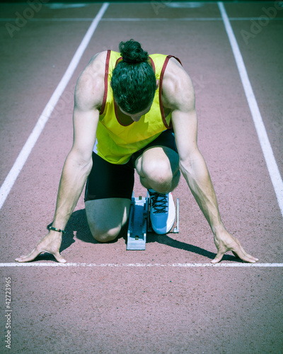 Photo: Male Track and Field Athlete before the Race Start Male Track and Field Athlete before the Race Start