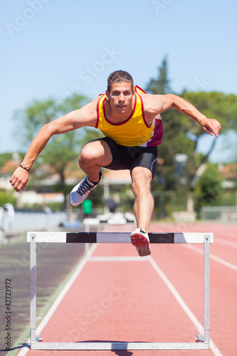 Photo: Male Track and Field Athlete during Obstacle Race Male Track and Field Athlete during Obstacle Race