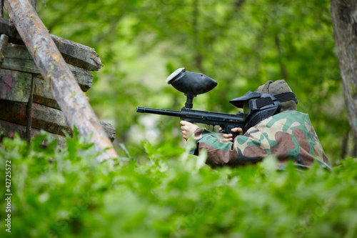 Photo: Paintball player in camouflage and protective mask Paintball player in camouflage and protective mask