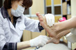 Master chiropody treats the sole skin of female client.