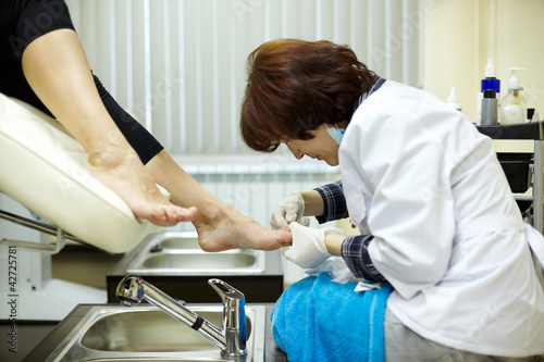 Photo: Chiropody master processes nails of client in beauty salon Chiropody master processes nails of client in beauty salon