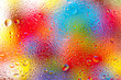 Wasserspritzer auf einer Scheibe mit buntem Hintergrund