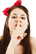 Portrait of teenage girl with silence sign on white background