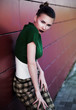 Beautiful city woman is leaning  on a street wall. Urban scene