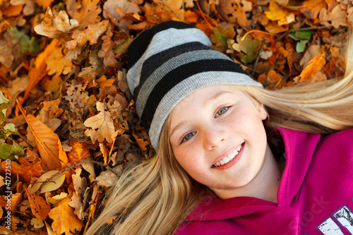 Photo: girl on autumn leaves smiling girl on autumn leaves smiling