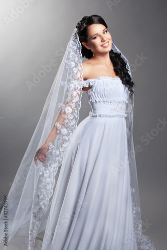Photo: beautiful bride is standing in wedding dress beautiful bride is standing in wedding dress