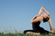 Photo: Yoga woman on green grass. Sky background. Yoga woman on green grass. Sky background.