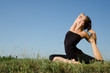 Photo: Yoga woman on green grass. Sky background. Yoga woman on green grass. Sky background.