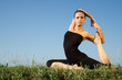 Photo: Yoga woman on green grass. Sky background. Yoga woman on green grass. Sky background.