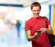 portrait of young man touching mobile screen indoor