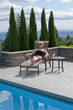 Attractive blond woman lounges by swimming pool