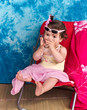 enfant de 10 mois avec lunettes de soleil assise