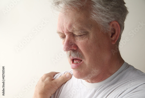 Photo: a man suffers from pain in his shoulder a man suffers from pain in his shoulder