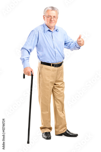 Foto: Mature man walking with cane and giving a thumb up Mature man walking with cane and giving a thumb up