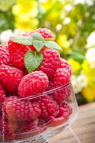 Foto: Sweet fresh raspberry fruits in glass goblet Sweet fresh raspberry fruits in glass goblet