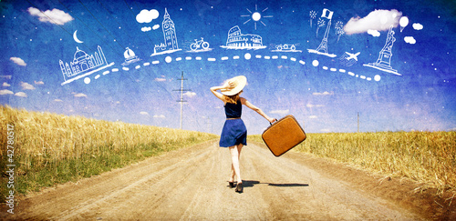 Photo: Lonely girl with suitcase at country road dreaming about travel. Lonely girl with suitcase at country road dreaming about travel.