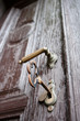 Closeup of an old wooden door with a big key in the lock