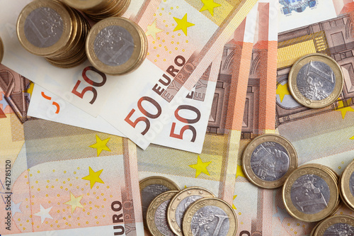 Photo: Euro coins on banknote money background Euro coins on banknote money background