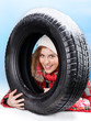 Foto: Beautiful woman with winter coat behind snowy winter tyre Beautiful woman with winter coat behind snowy winter tyre