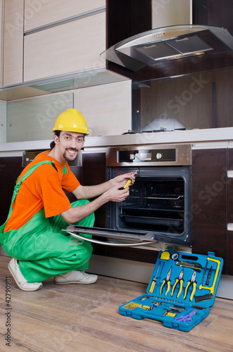 Photo: Repairman assembling the furniture at kitchen Repairman assembling the furniture at kitchen