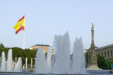 Foto: Water fountain and Spanish flag waves behind statue of Christopher Columbus at Plaza de Col—n in Madrid, Spain Water fountain and Spanish flag waves behind statue of Christopher Columbus at Plaza de Col—n in Madrid, Spain