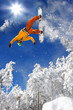Snowboarder jumping against blue sky