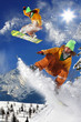 Snowboarders jumping against blue sky