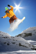 Snowboarder jumping against blue sky