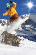Snowboarder jumping against blue sky