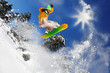 Snowboarder jumping against blue sky