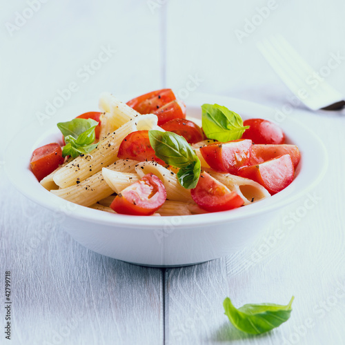 Photo: Bowl of pasta salad with cherry tomatoes and basil Bowl of pasta salad with cherry tomatoes and basil