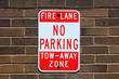 No parking sign posted on a brick wall