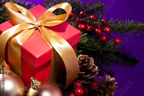 Photo: Red present box in a Christmas setting close up shoot Red present box in a Christmas setting close up shoot