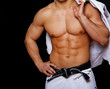 Close portrait of muscle man in kimono posing on black backgroun