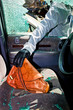 Ein Dieb entwendet eine Handtasche aus Auto