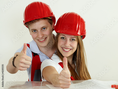 Photo: Young worker fixing up a house and showing thumbs up Young worker fixing up a house and showing thumbs up