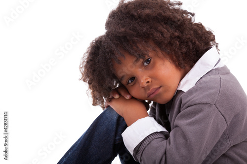 Photo: Portrait of an african american little boy sitting on the floor Portrait of an african american little boy sitting on the floor