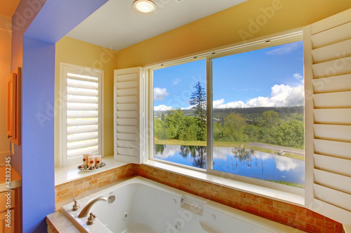 Photo: Modern bathroom with large tub and lake view. Modern bathroom with large tub and lake view.