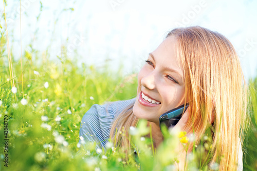 Photo: Beautiful Teenage Girl talking on the Phone outdoors Beautiful Teenage Girl talking on the Phone outdoors