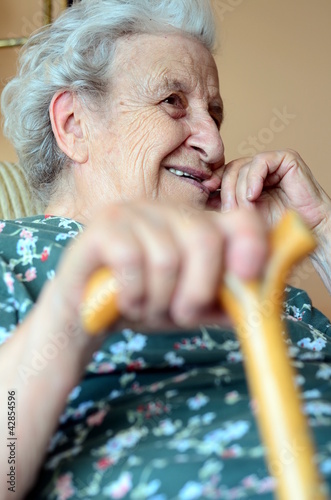 Photo: senior woman holding wooden cane senior woman holding wooden cane