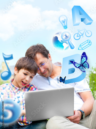 Photo: Closeup portrait of happy family: father and his son educating u Closeup portrait of happy family: father and his son educating u
