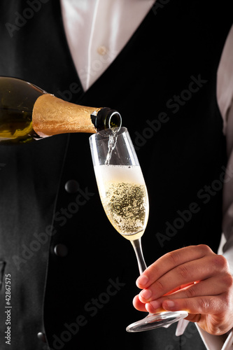 Photo: Waiter serving a glass of champagne Waiter serving a glass of champagne