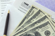 Photo: Tax papers with 100 dollar bills Tax papers with 100 dollar bills