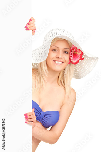 Foto: An attractive blond woman in swimsuit holding a white panel An attractive blond woman in swimsuit holding a white panel