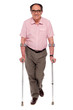 Smiling senior man walking with two crutches